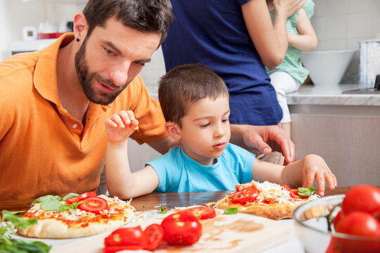 Father and son making homemade pizza