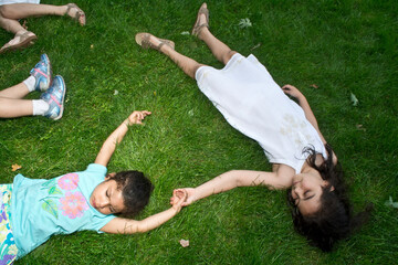 Four girls lying on their backs in park at summer camp