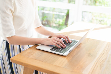 Fototapeta premium 部屋でパソコンを見る女性 手元