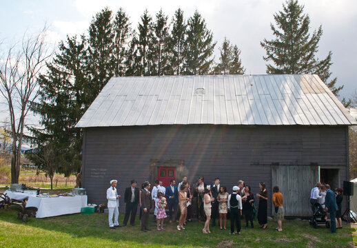 Large group of wedding guests gathered outside barn
