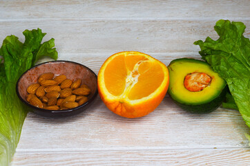 fresh vegetables and fruits, avocado, orange, lettuce, almonds, healthy and vegan food, diet concept, detox, body weight control, products for immunity