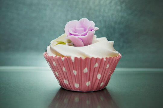 Still life of iced cupcake in pink spotted case