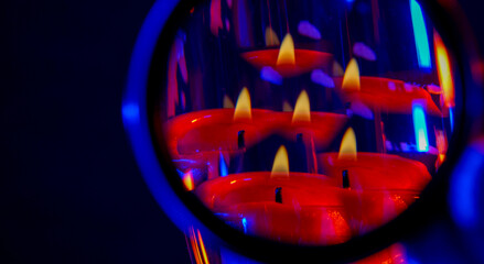 Selective focus closeup of the reflection of lighted candles on a mirror