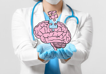 Female doctor with holographic projection of human brain on light background. Innovative technologies in medicine