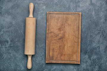 Rolling pin and board on dark background