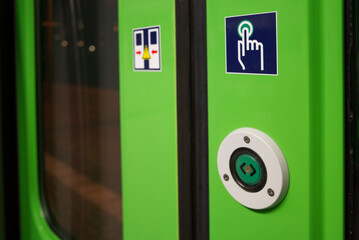 Close-up view at Green Push button for open the door on train's automatic door of regional train in...