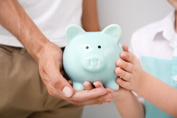 Obraz na płótnie Canvas Hands of family with piggy bank. Money savings concept