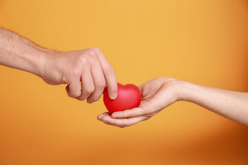 Hands of family with heart on color background