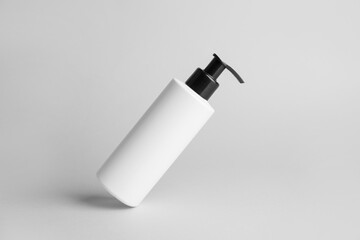Bottle of cosmetic product on light background