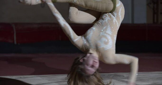 Flexible young woman is doing aerial silks on stage of the circus, athletic, 4k