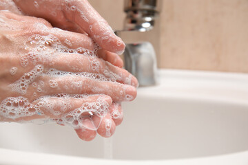 Fototapeta premium Young woman washing her hands in bathroom, closeup