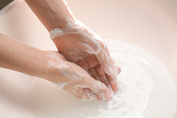 Fototapeta premium Young woman washing her hands in bathroom, closeup