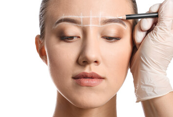 Young woman undergoing eyebrow correction procedure on white background
