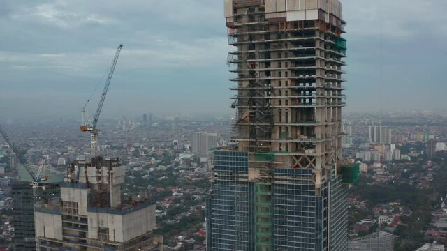 Close up aerial shot of skyscraper bare skeleton frame under construction in Jakarta, Indonesia