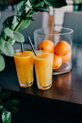 Orange juice in glass with fresh fruits on wooden background