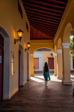 mujer caminando en mompox con un vestido verde 
