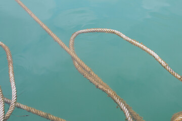 Rope floating on surface of the deep blue sea background. covered with algae.