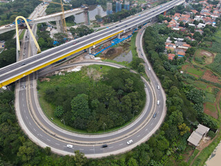 Aerial drone view of highway multilevel junction road with moving cars and noise cloud. BEKASI, INDONESIA : JANUARY 14 2021