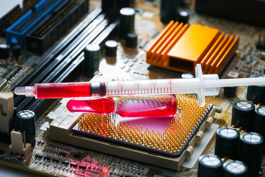 glass ampoule with red medicine with syringe on socket with cpu chip with contact legs on motherboard with microelectronic components, theme of cybernetics and implantation chipization, nobody.
