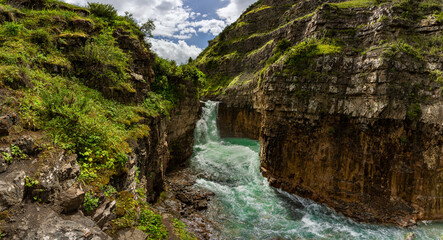 Fototapeta na wymiar beautiful waterfall among green rocks
