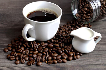 Fototapeta premium Coffee cup, coffee beans and milk jug on the table.