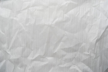 Crumpled white plastic foam foil texture perfect for background structure. Packaging material with rough wrinkles. The grunge textured surface can be used as backdrop.