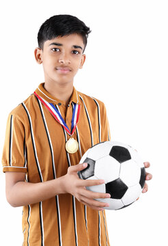  Indian school boy holding soccer ball and medal in hands