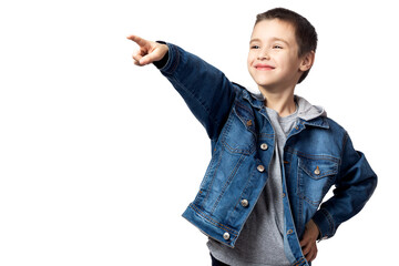 Portrait of a smiling boy  in a denim jacket  points the direction, and rejoices at his achievements, has fun on a white isolated background