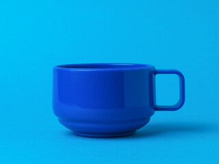 Blue cup for tea or coffee on a blue background.