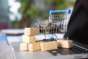 Shopping cart full of euro coins and goods on computer keyboard