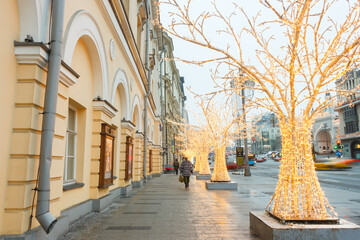 Moscow, Russia, Dec 31, 2020:  New Year decorated trees in Teatralny passage. Wall of the Maly Theater.