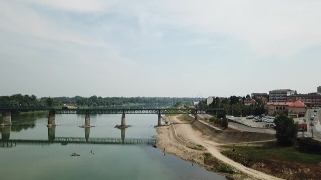 A drone view of the Brcko railroad bridge over a river surrounded by buildings in Bosnia and Herzegovina shot in HD