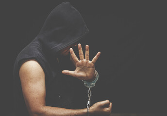Handcuffed hand of a prisoner in prison, dangerous criminal punished by law