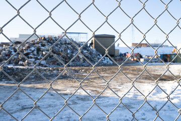 Chain link fence with Garbage recycle dump behind it
