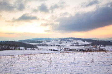 Fototapeta na wymiar Zauberhafte Winterlandschaft, Schnee und einen Hügel im Hintergrund während des Sonnenunterganges
