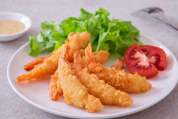 Fried breaded shrimp with vegetable on plate and plum sauce