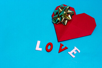 Greeting card in the shape of a big red heart and the inscription love