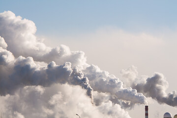 industrial chimneys with heavy smoke causing air pollution on the blue sky background