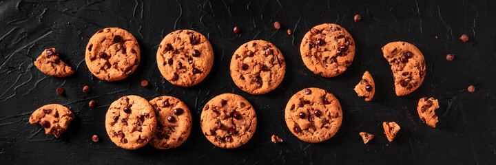 Chocolate chip cookies panorama on a black background, shot from the top