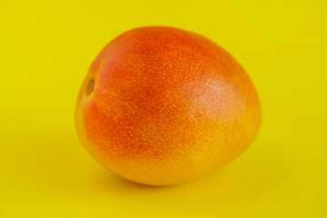 ripe fresh mango on yellow background
