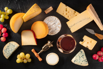 Cheese and wine, overhead flat lay on a dark background