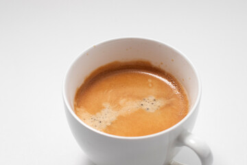 Closeup of Coffee cream on the freshly brewed coffee. Cup of cappuccino in a white mug