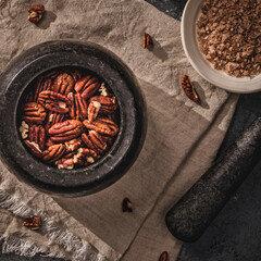 Top angle view of pecan in mortar on a linen cloth, -image