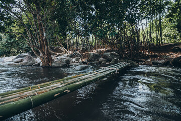 Bamboo bridge cross the water in waterfall.  Nature and relax time concept.