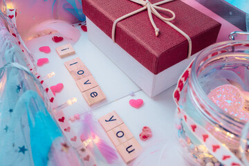 wooden letter block word " I love your", feather, little gift box, heart shape and light decorative in box present. Love, Valentine and holiday concept.