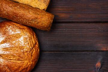 Fresh bread on a dark wooden table. View from above.