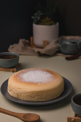 Vertical low angle view of a Japanese cheesecake with tea sets, -image