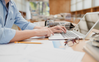 Businessman using laptop for working and hold cup of coffee in the office. Business professional concept.