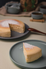 Vertical low angle view of a Japanese cheesecake with tea sets, -image