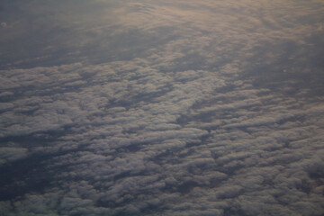 spectacular sunset seen from an airplane with clouds in the foreground and in the distance
